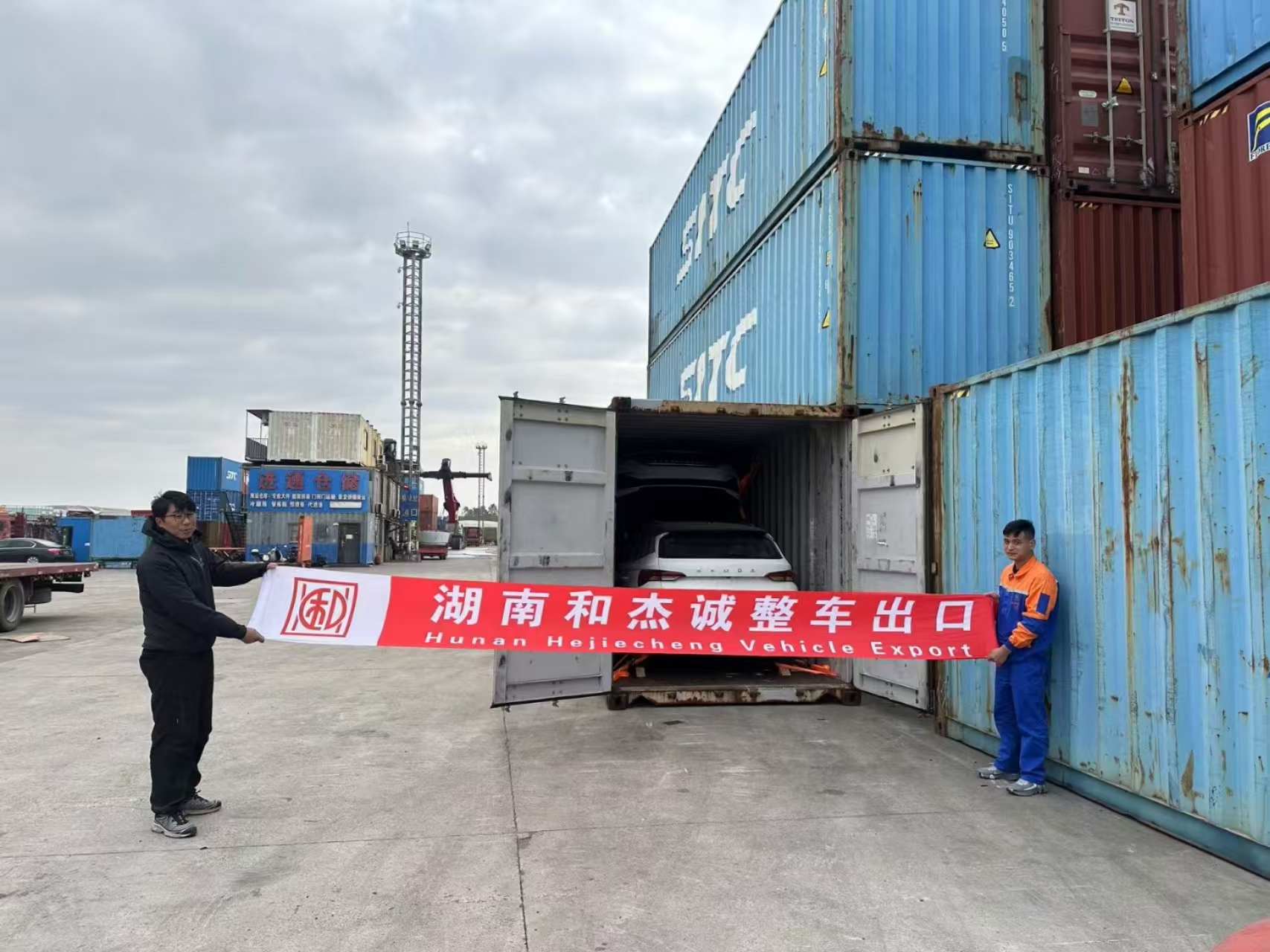 SITC terminal with Hejiecheng banner, SUV loaded into container